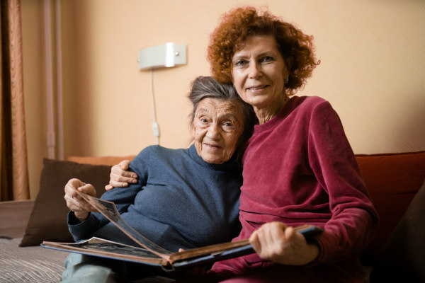 Carer and elderly lady looking at a photo album