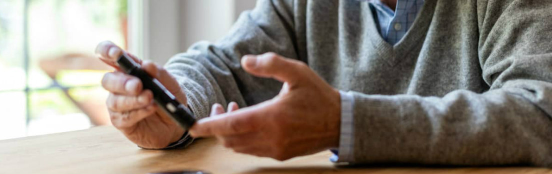 elderly man  holiding his mobile phone about to make a call