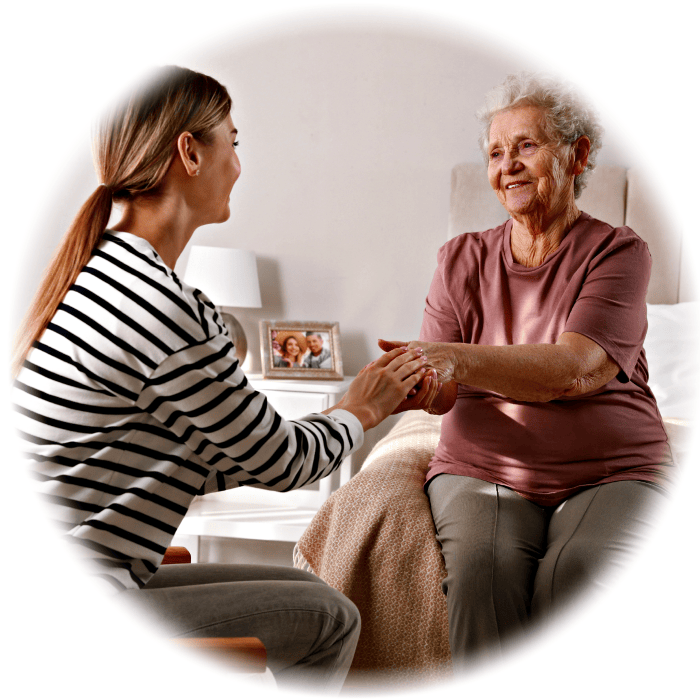 Young woman holding elderly lady's hands, smiling warmly