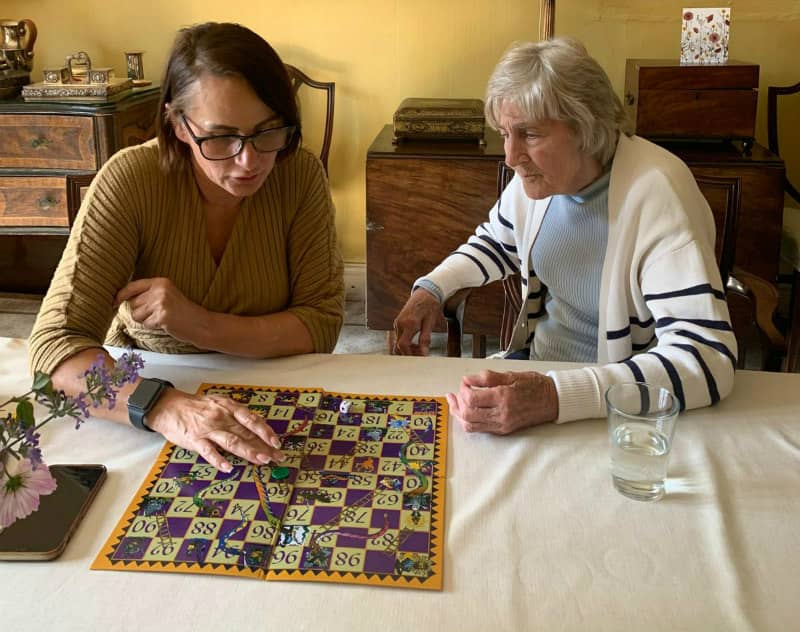 Two women playing a board game at a home table