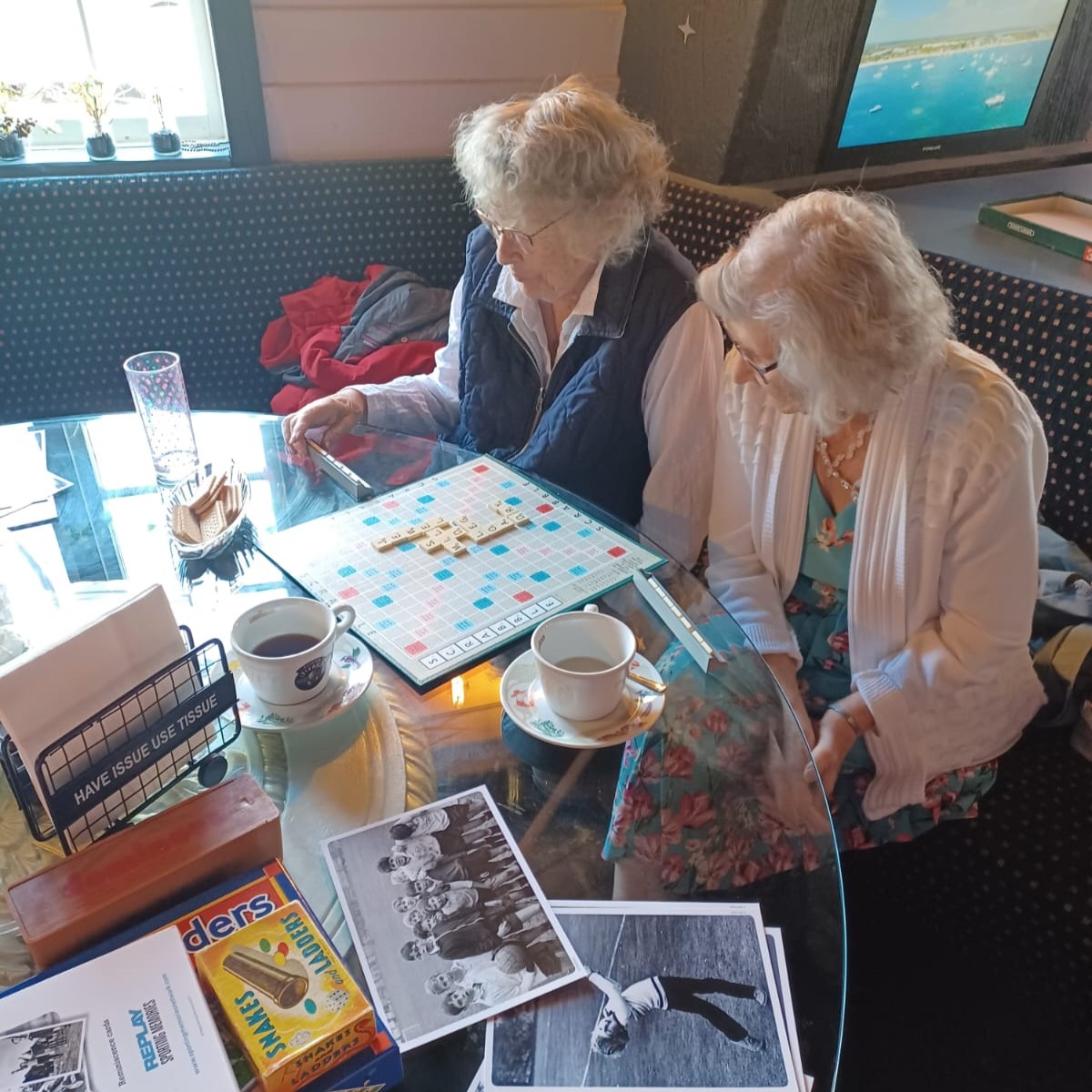 Elderly women playing Scrabble in a cozy cafe