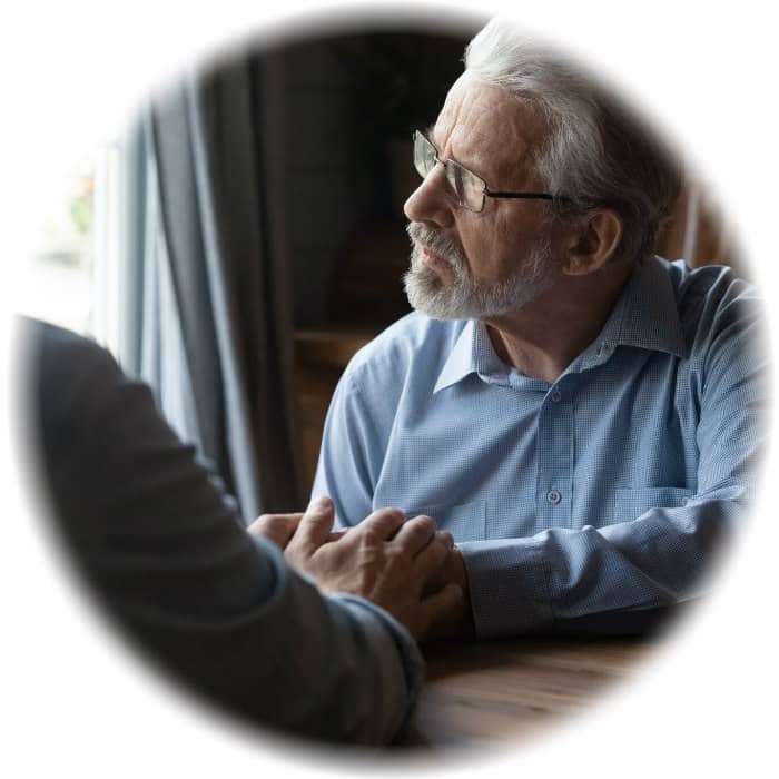 Elderly man gazing thoughtfully out a window