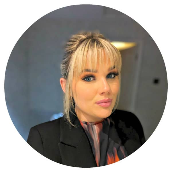 Woman with bangs smiling in black blazer